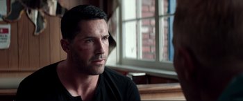 Movie still from “Debt Collectors” (2020), directed by Jesse V. Johnson – A person sitting in front of a window; Close Up shot, Over the shoulder angle