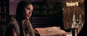 Movie still from “Debt Collectors” (2020), directed by Jesse V. Johnson – A woman sitting at a table with a purse in front of her; Close Up shot, Over the shoulder angle