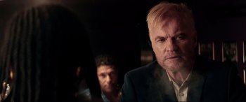 Movie still from “Debt Collectors” (2020), directed by Jesse V. Johnson – A man in a black suit and a man in a blue suit; Close Up shot, Over the shoulder angle