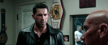 Movie still from “Debt Collectors” (2020), directed by Jesse V. Johnson – A person wearing a leather jacket; Close Up shot, Over the shoulder angle