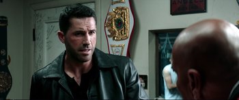 Movie still from “Debt Collectors” (2020), directed by Jesse V. Johnson – A person wearing a leather jacket; Close Up shot, Over the shoulder angle