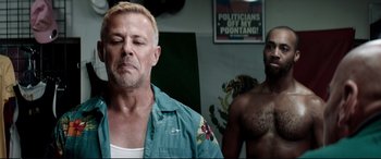 Movie still from “Debt Collectors” (2020), directed by Jesse V. Johnson – A man in a blue shirt is standing next to another man; Close Up shot, Low angle