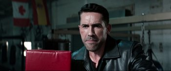 Movie still from “Debt Collectors” (2020), directed by Jesse V. Johnson – A person wearing a leather jacket; Close Up shot, Over the shoulder angle