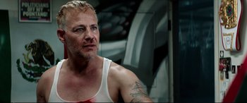 Movie still from “Debt Collectors” (2020), directed by Jesse V. Johnson – A person wearing a tank top; Close Up shot, Low angle