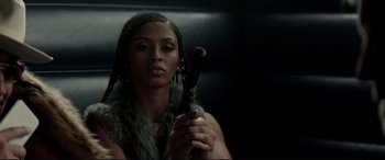 Movie still from “Debt Collectors” (2020), directed by Jesse V. Johnson – A woman holding an object in her hand; Close Up shot, Low angle