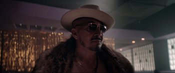 Movie still from “Debt Collectors” (2020), directed by Jesse V. Johnson – A person wearing a hat and sunglasses; Close Up shot, Low angle