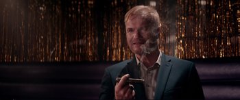 Movie still from “Debt Collectors” (2020), directed by Jesse V. Johnson – A man in a blue suit smoking a cigarette; Close Up shot, Over the shoulder angle