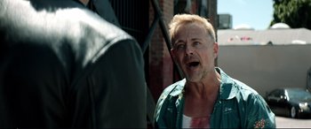 Movie still from “Debt Collectors” (2020), directed by Jesse V. Johnson – A man with a beard is talking to another man outside; Close Up shot, Over the shoulder angle