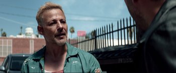 Movie still from “Debt Collectors” (2020), directed by Jesse V. Johnson – A person wearing a green shirt; Close Up shot, Over the shoulder angle