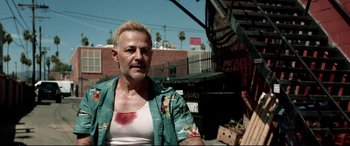 Movie still from “Debt Collectors” (2020), directed by Jesse V. Johnson – A man with a tattoo on his arm and a shirt with blood all over his chest; Close Up shot, Low angle