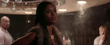 Movie still from “Debt Collectors” (2020), directed by Jesse V. Johnson – A woman in a fur vest looking to her left; Close Up shot, Over the shoulder angle