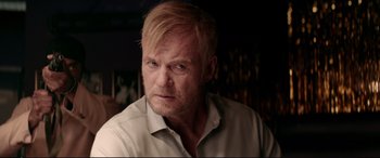 Movie still from “Debt Collectors” (2020), directed by Jesse V. Johnson – A person wearing a white shirt; Close Up shot, Over the shoulder angle