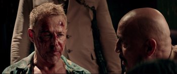 Movie still from “Debt Collectors” (2020), directed by Jesse V. Johnson – A man with blood all over his face and a bald man with a beard; Close Up shot, Over the shoulder angle