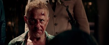 Movie still from “Debt Collectors” (2020), directed by Jesse V. Johnson – A person with blood on his face; Close Up shot, Over the shoulder angle