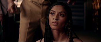 Movie still from “Debt Collectors” (2020), directed by Jesse V. Johnson – A beautiful woman with long black braids looking at the camera; Close Up shot, Over the shoulder angle