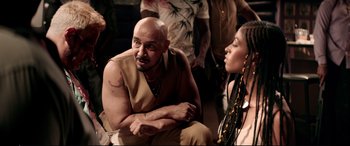 Movie still from “Debt Collectors” (2020), directed by Jesse V. Johnson – A man and a woman sitting next to each other; Medium shot, Over the shoulder angle