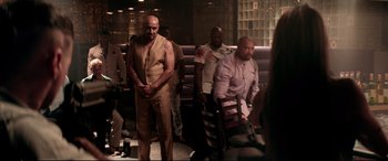 Movie still from “Debt Collectors” (2020), directed by Jesse V. Johnson – A group of men standing in a room; Wide shot, Over the shoulder angle