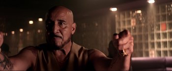 Movie still from “Debt Collectors” (2020), directed by Jesse V. Johnson – A man with a bald head is holding something in his right hand; Close Up shot, Low angle