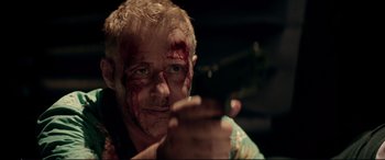 Movie still from “Debt Collectors” (2020), directed by Jesse V. Johnson – A person with blood all over his face; Close Up shot, Low angle