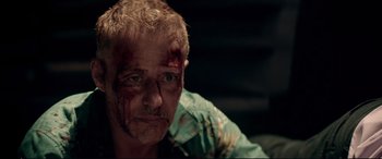 Movie still from “Debt Collectors” (2020), directed by Jesse V. Johnson – A person with blood all over his face; Close Up shot, Over the shoulder angle