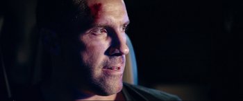 Movie still from “Debt Collectors” (2020), directed by Jesse V. Johnson – A person with a bruise on his face; Close Up shot, Over the shoulder angle