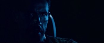 Movie still from “Debt Collectors” (2020), directed by Jesse V. Johnson – A person in a dark room; Close Up shot, Low angle