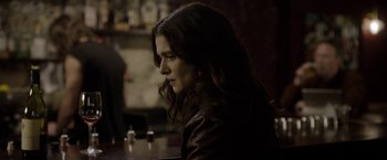 Movie still from “Disobedience” (2017), directed by Sebastián Lelio – A woman sitting at a table in front of a glass of wine; Close Up shot, Over the shoulder angle