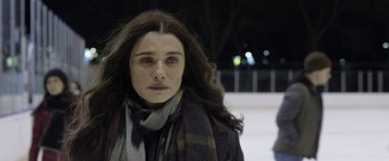 Movie still from “Disobedience” (2017), directed by Sebastián Lelio – A person wearing a coat and a scarf; Close Up shot, Over the shoulder angle