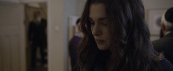 Movie still from “Disobedience” (2017), directed by Sebastián Lelio – A person with long brown hair; Close Up shot, Over the shoulder angle