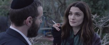 Movie still from “Disobedience” (2017), directed by Sebastián Lelio – A man and a woman are talking to each other outside; Close Up shot, Over the shoulder angle