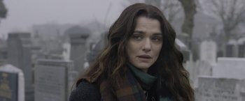 Movie still from “Disobedience” (2017), directed by Sebastián Lelio – A person with long hair wearing a scarf; Close Up shot, Over the shoulder angle