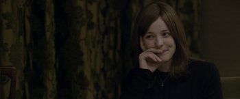 Movie still from “Disobedience” (2017), directed by Sebastián Lelio – A young woman smiles while posing for a picture; Close Up shot, Over the shoulder angle