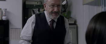 Movie still from “Disobedience” (2017), directed by Sebastián Lelio – An older man wearing a vest and a tie; Close Up shot, Over the shoulder angle