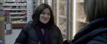 Movie still from “Disobedience” (2017), directed by Sebastián Lelio – A woman wearing a black jacket and a purple scarf; Close Up shot, Over the shoulder angle