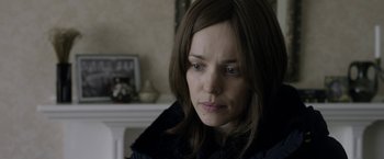 Movie still from “Disobedience” (2017), directed by Sebastián Lelio – A person sitting in front of a fireplace; Close Up shot, Over the shoulder angle