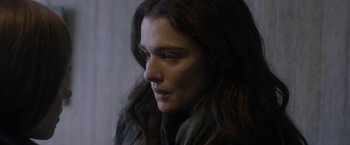 Movie still from “Disobedience” (2017), directed by Sebastián Lelio – A person with long dark hair; Close Up shot, Over the shoulder angle