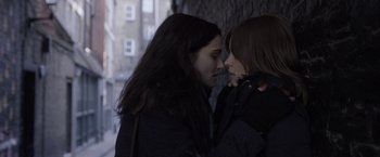 Movie still from “Disobedience” (2017), directed by Sebastián Lelio – Two young women standing next to each other; Close Up shot, Over the shoulder angle