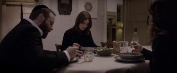 Movie still from “Disobedience” (2017), directed by Sebastián Lelio – A woman sitting at a table with a bowl of salad; Medium shot, Over the shoulder angle