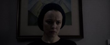 Movie still from “Disobedience” (2017), directed by Sebastián Lelio – A woman wearing a black t - shirt and a black hat; Close Up shot, Over the shoulder angle