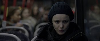 Movie still from “Disobedience” (2017), directed by Sebastián Lelio – A woman in a black hat is sitting on a bus; Close Up shot, Over the shoulder angle