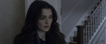 Movie still from “Disobedience” (2017), directed by Sebastián Lelio – A person with long dark hair; Close Up shot, Over the shoulder angle