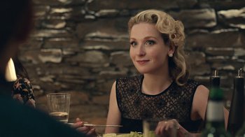 Movie still from “Black Mirror” (2011), created by Charlie Brooker – A woman sitting at a table with a plate of food; Close Up shot, Over the shoulder angle