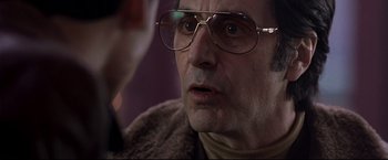 Movie still from “Donnie Brasco” (1997), directed by Mike Newell – An older man wearing glasses and a fur coat; Close Up shot, Over the shoulder angle