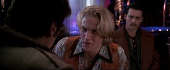 Movie still from “Donnie Brasco” (1997), directed by Mike Newell – A man with long blonde hair wearing a floral shirt; Close Up shot, Over the shoulder angle
