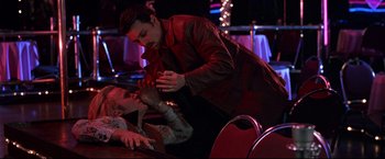 Movie still from “Donnie Brasco” (1997), directed by Mike Newell – A man and a woman in a dark room; Medium shot, High angle