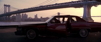 Movie still from “Donnie Brasco” (1997), directed by Mike Newell – A man sitting in the driver's seat of an old car; Wide shot, Low angle