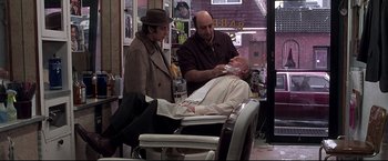 Movie still from “Donnie Brasco” (1997), directed by Mike Newell – A man getting his teeth brushed in a barber shop; Medium shot, Over the shoulder angle