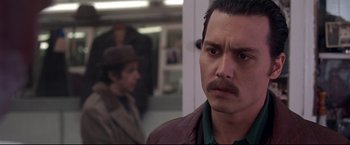 Movie still from “Donnie Brasco” (1997), directed by Mike Newell – A person with a mustache wearing a hat; Close Up shot, Over the shoulder angle