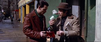 Movie still from “Donnie Brasco” (1997), directed by Mike Newell – Two men are looking at a red wallet; Medium shot, Over the shoulder angle