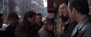 Movie still from “Donnie Brasco” (1997), directed by Mike Newell – A group of men standing on a city street; Medium shot, Over the shoulder angle